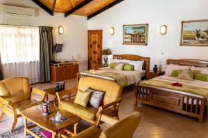 Au Cap卡瓦列罗别墅酒店的一间带两张床的卧室和一间客厅