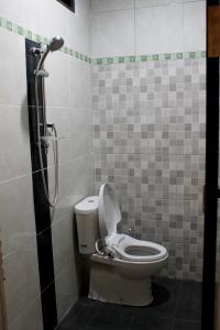 库塔赤林库塔民宿的一间带卫生间和淋浴的浴室