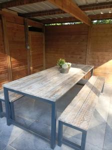 WingeneWoning gelegen in rustige bosrijke omgeving的天井上的野餐桌和长凳
