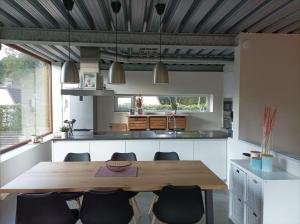WingeneWoning gelegen in rustige bosrijke omgeving的开放式厨房配有木桌和椅子