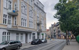 霍茹夫Apartamenty Chorzów obok Parku Śląskiego的2辆汽车停在城市街道上,街道上有许多建筑