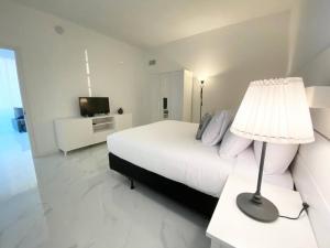 迈阿密海滩Zen Vacation Rentals Modern Penthouse Across Ocean的白色卧室配有床和灯