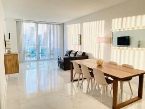 迈阿密海滩Zen Vacation Rentals Modern Penthouse Across Ocean的客厅配有桌椅和沙发