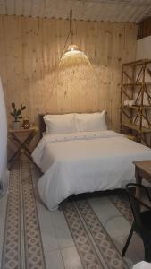 GuarinocitoTuku,的卧室配有一张白色大床和吊灯。