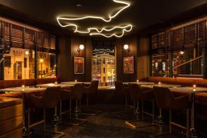 芝加哥The Robey, Chicago, a Member of Design Hotels的餐厅设有桌椅和 ⁇ 虹灯标志