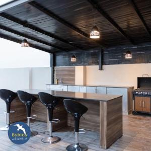 阿尔哈德Byblos Villa Resort的厨房配有木桌和黑色凳子