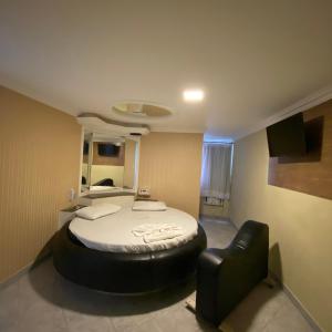 萨尔瓦多Hotel Milenium Itapuã的一间卧室配有一张床和一张黑色皮椅