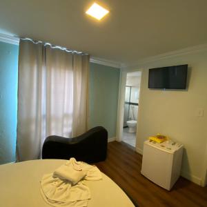萨尔瓦多Hotel Milenium Itapuã的客房设有床、电视和浴室。