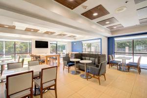 康科德Holiday Inn Express & Suites Charlotte-Concord-I-85, an IHG Hotel的用餐室设有桌椅和窗户。