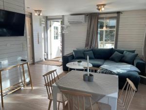 TyresöCozy cabin, neighbour to lake & national park的客厅配有蓝色的沙发和桌子