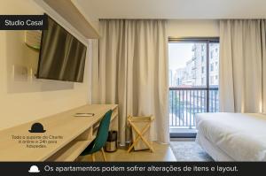 圣保罗Charlie Sabiá Moema的酒店客房设有一张桌子、一张床和一个窗户。