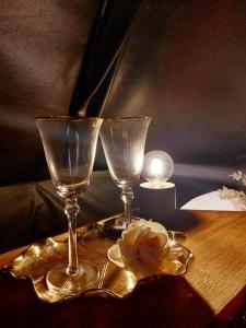 Glamping in - luxury tent的两杯酒和一朵花在桌子上
