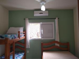 卡拉瓜塔图巴Canto Verde Aptos II的一间卧室设有两张双层床和一扇窗户。