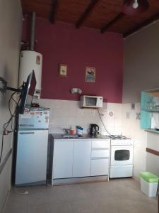 内科切阿Casa en Necochea的厨房配有白色家电和紫色墙壁