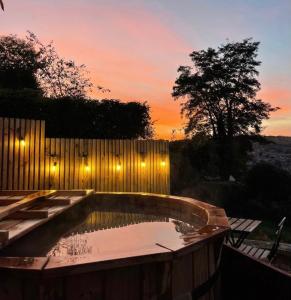 巴斯Secluded lodge with spectacular views and hot tub!的后院游泳池,设有围栏,享有日落美景