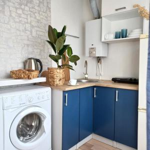 纳尔瓦Narva Relax Apartment的厨房配有蓝色橱柜和洗衣机。