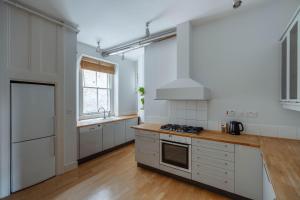 伦敦Bright Space in the Heart of London的厨房配有白色橱柜和炉灶烤箱。