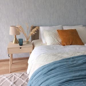 纳尔瓦Narva Relax Apartment的一间卧室配有一张床和一张带台灯的桌子