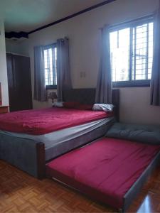 马尼拉Balili Property at Metro Manila Hills Subd Rodriguez Rizal的卧室设有两张床,配有红色床单和窗户