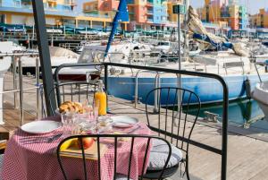 阿尔布费拉The Homeboat Company Albufeira的一个带食物的桌子,阳台上有码头