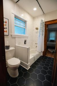 格尔夫波特Gulf Coast Craftsman - Cozy, Charming & Central!的浴室配有卫生间、浴缸和水槽。