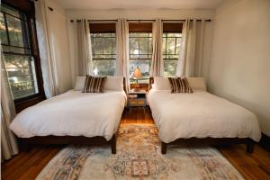 格尔夫波特Gulf Coast Craftsman - Cozy, Charming & Central!的配有窗户和地毯的客房内的两张床