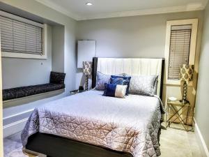 温哥华新都市现代主街科奇度假屋的一间卧室配有一张带蓝色枕头的床和一扇窗户。