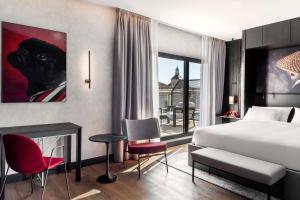 马德里Radisson RED Madrid的酒店客房配有一张床和一个壁炉。
