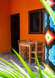 圣法兰西斯克DownTown Rooms San Pancho的橙色墙壁的房间里摆放着桌椅