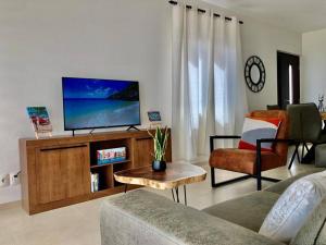 Dorp Sint MichielThe beach House- 1Room Apartment at Blue Bay resort的客厅配有电视、沙发和桌子