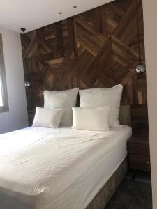 阿加迪尔New Luxury Apartment Sea View的一张配有白色床单和木墙的大床