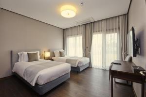 济州市樟树酒店及度假村 的酒店客房配有两张床和一张书桌