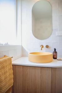 爱丽丝湾Sunnymead Hotel的浴室设有黄色水槽和镜子