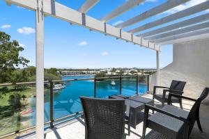 努萨角太阳湖度假酒店的阳台配有桌椅,享有水景。
