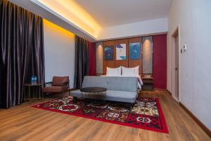 TakengonParkside Gayo Petro Hotel Takengon的一间卧室配有一张床和红色地毯