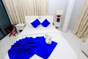 科托努Hotel Galilée的卧室配有蓝色遮阳伞。