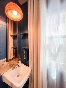 圣地亚哥ITH Mission Beach Backpacker Hostel的一间带水槽和镜子的浴室以及窗户。