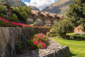 乌鲁班巴卡萨安迪娜尊贵神圣山谷酒店及别墅的一座花卉和石墙的房子