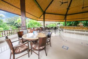 库塔峇里岛棕榈滩大酒店的一间带桌椅和阳台的餐厅
