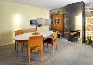 塞亚卡萨斯多索伊托公寓的厨房配有桌椅和壁炉。