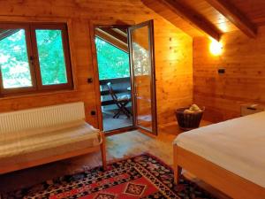 比哈奇Kuća u šumi - Forest house near National park Una - Air Spa Lohovo的小屋内一间卧室配有床和窗户