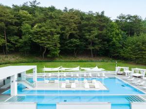 南原市南原套房酒店 的一个带白色椅子的游泳池和一个泳池景