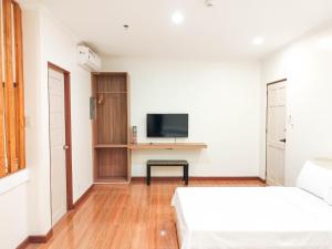 碧瑶Eekos Hotels的白色的客房配有两张床和电视。
