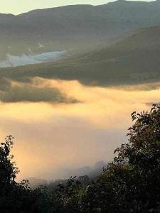 Cabezas BajasApartamento rural El Pastor es un estudio con gran ventanal a Gredos的天空中云层的山谷景色