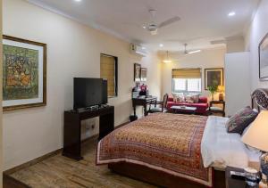 加尔各答Neelam Bed & Breakfast的一间酒店客房,配有一张床和一台电视