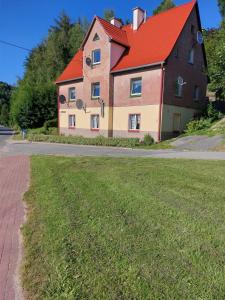 杜什尼基-兹德鲁伊Apartament Rosiczka的街上有红色屋顶的大房子