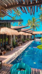 爱妮岛Banig Beach Resort El Nido的一个带遮阳伞的游泳池和一个度假村