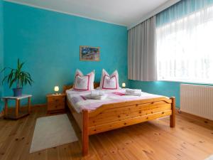 阿尔滕基兴Ferienwohnung Käthe in Altenkirchen的一间卧室设有一张床和蓝色的墙壁