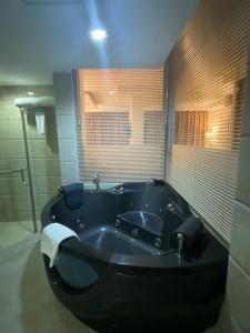 Mawāliḩ城市中心酒店的浴室内设有大型黑色浴缸。