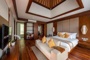 努沙杜瓦Tanadewa Villas Nusa Dua Bali by Cross Collection的一间卧室配有一张大床和电视